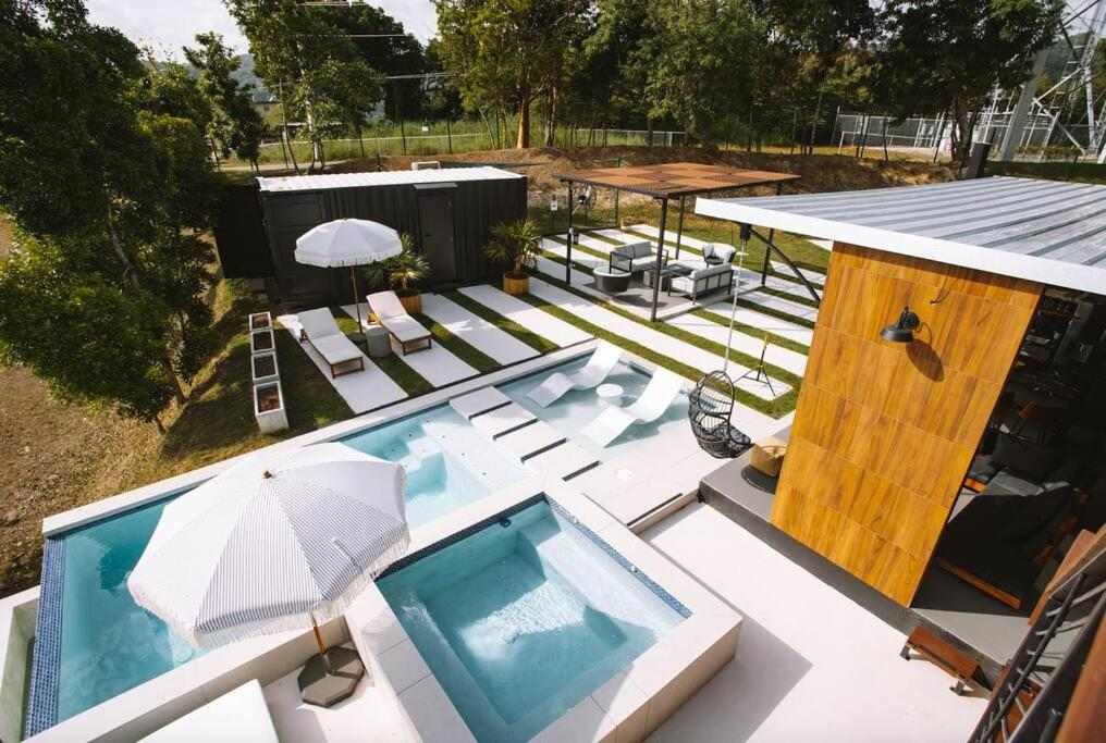 Vista aérea de la piscina, el jacuzzi y la villa de contenedores negra mate